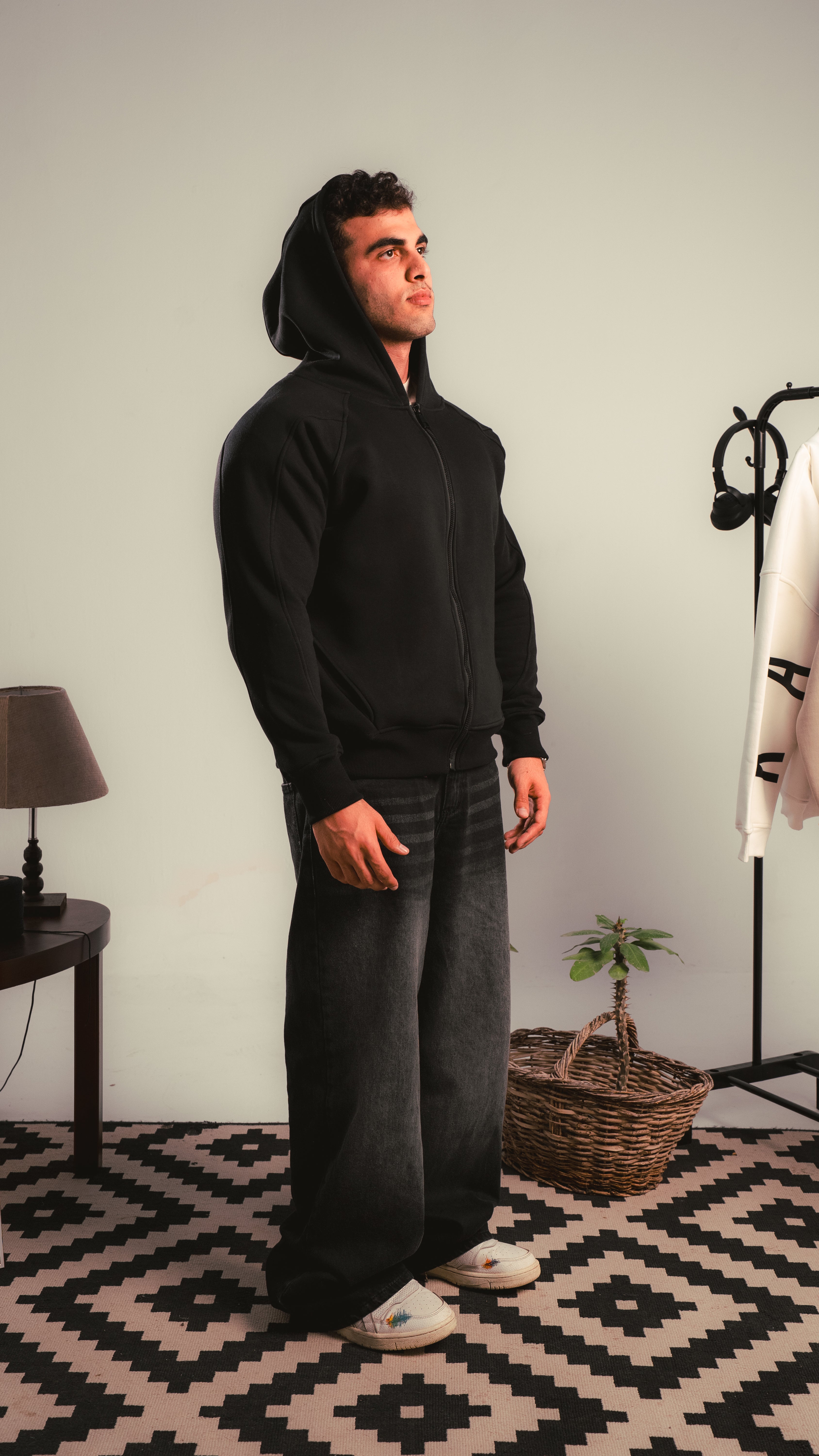 Side view of model wearing a black zip hoodie — KALIUM