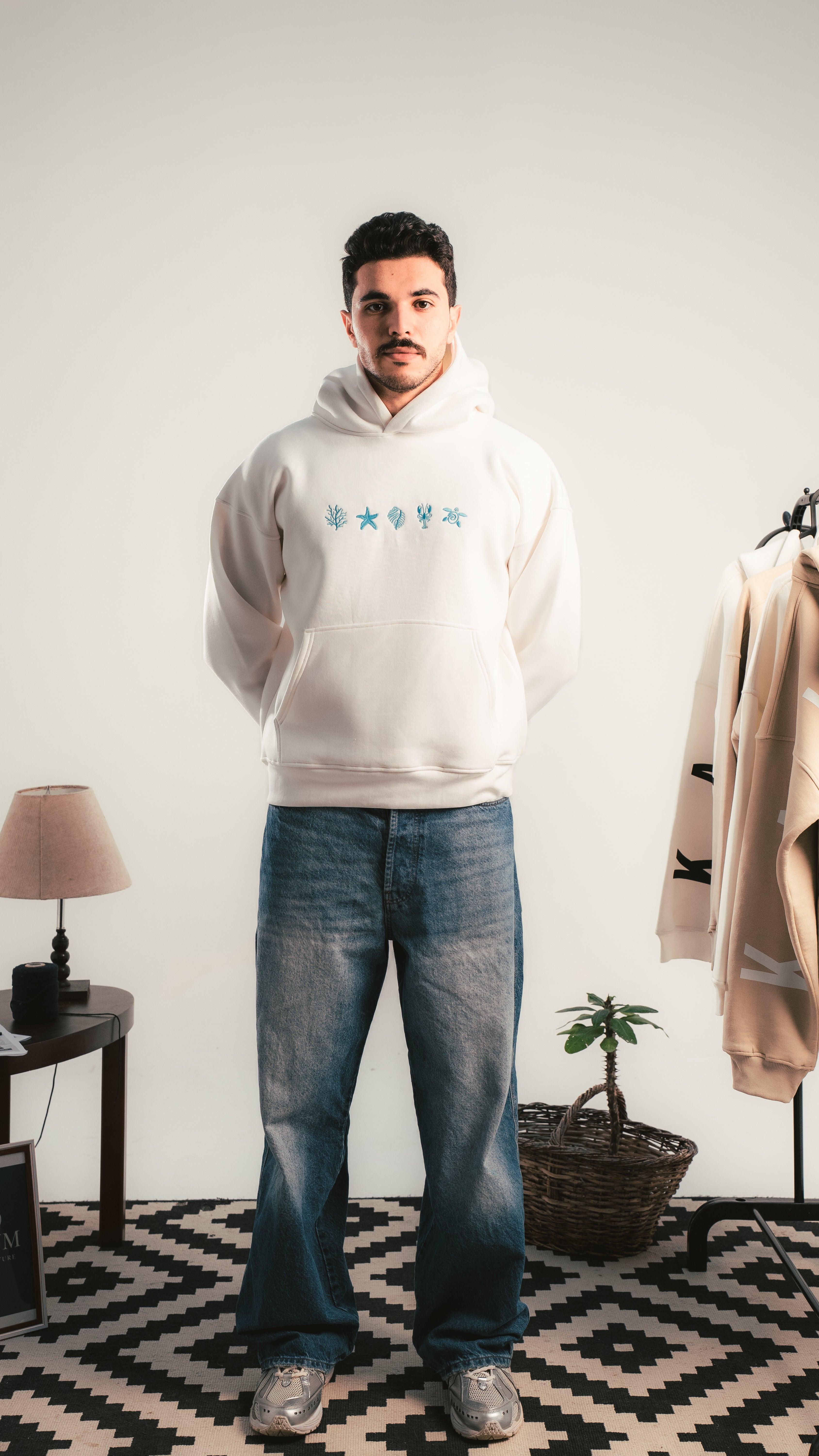 شاب يرتدي هودي أبيض بتصميم رموز زرقاء من الأمام — Kalium