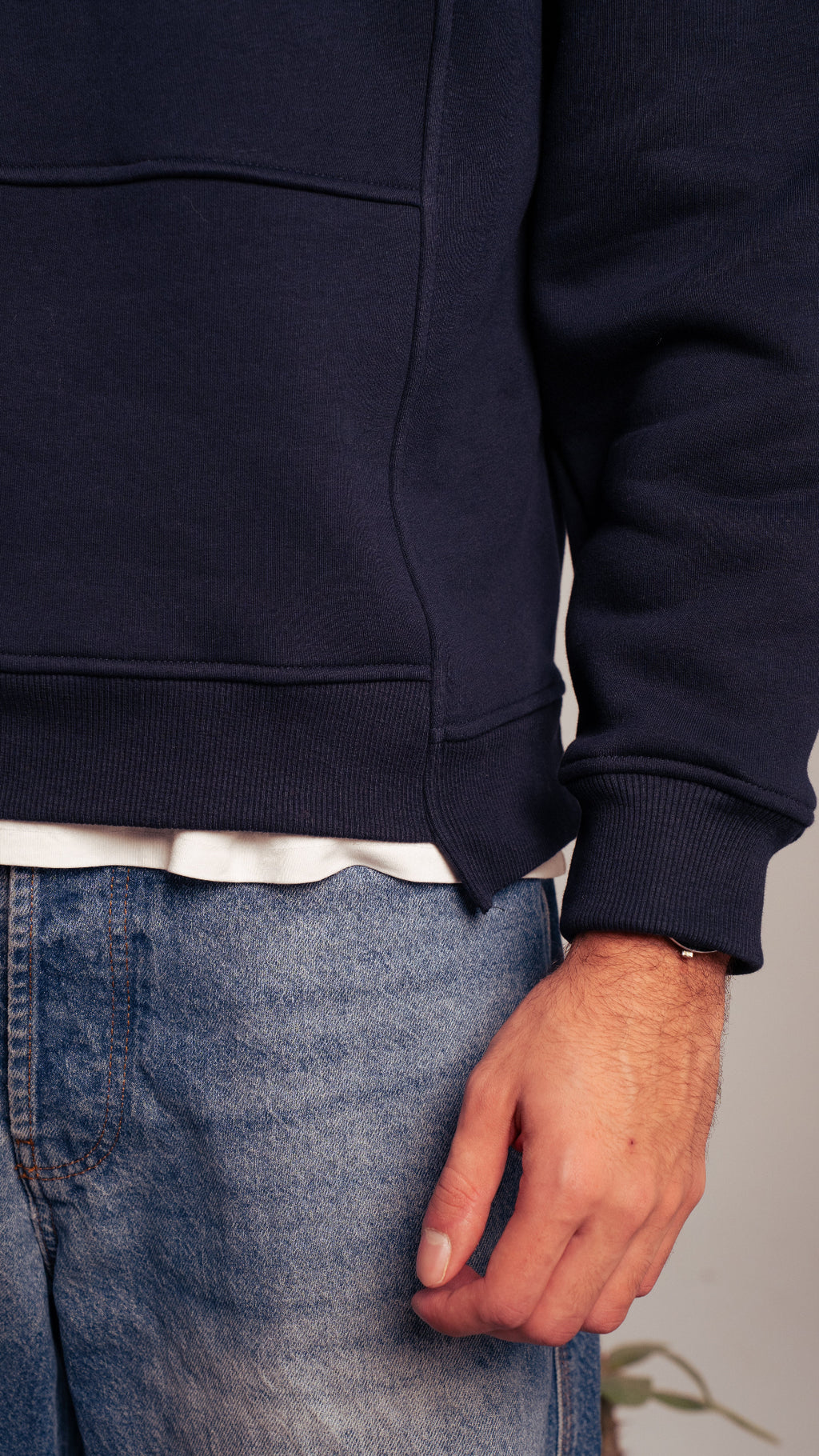 Close-up of navy Kalium sweatshirt showing fabric texture and front pocket.
