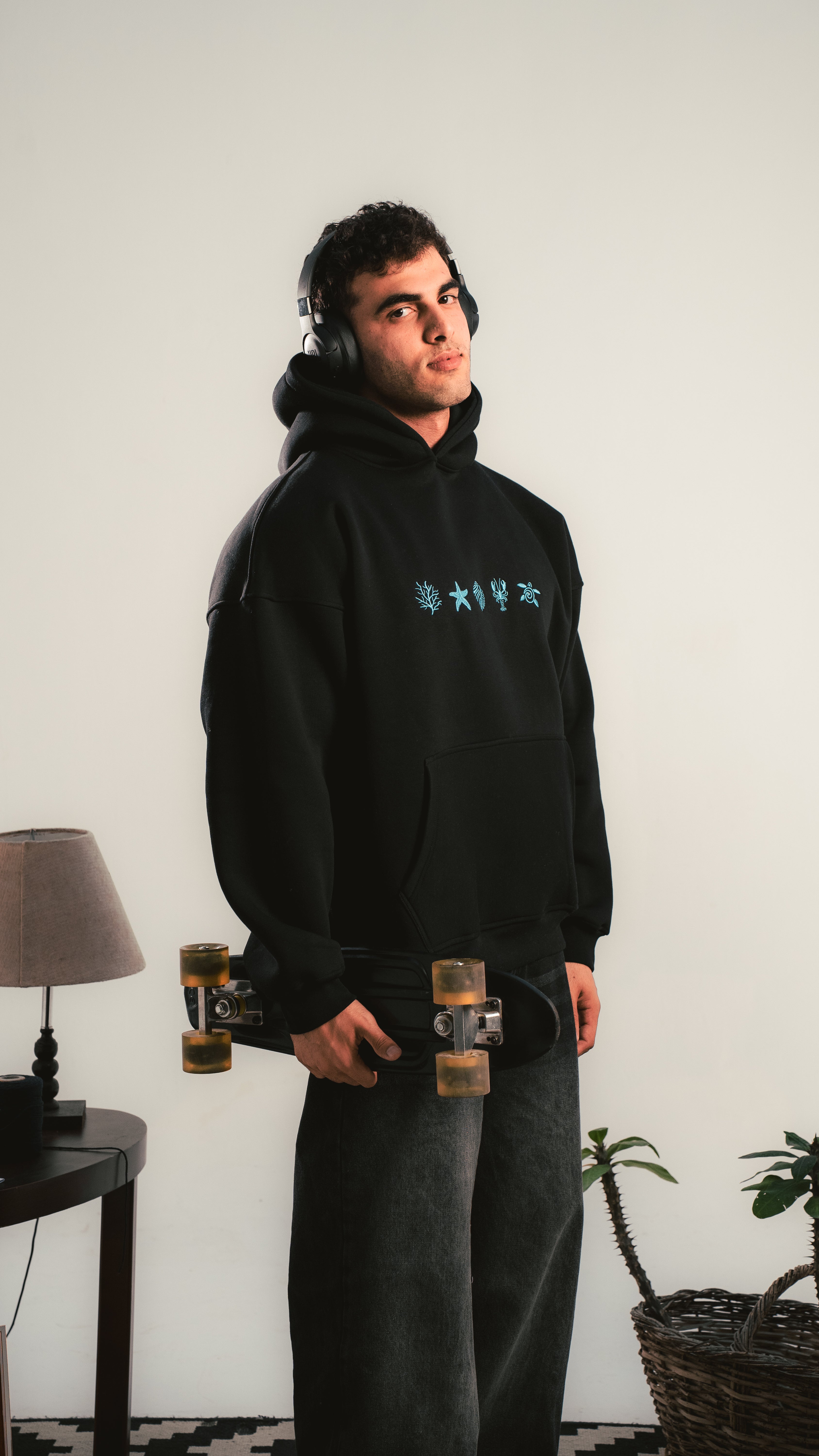 Young man wearing a black hoodie with blue minimal graphics — Kalium