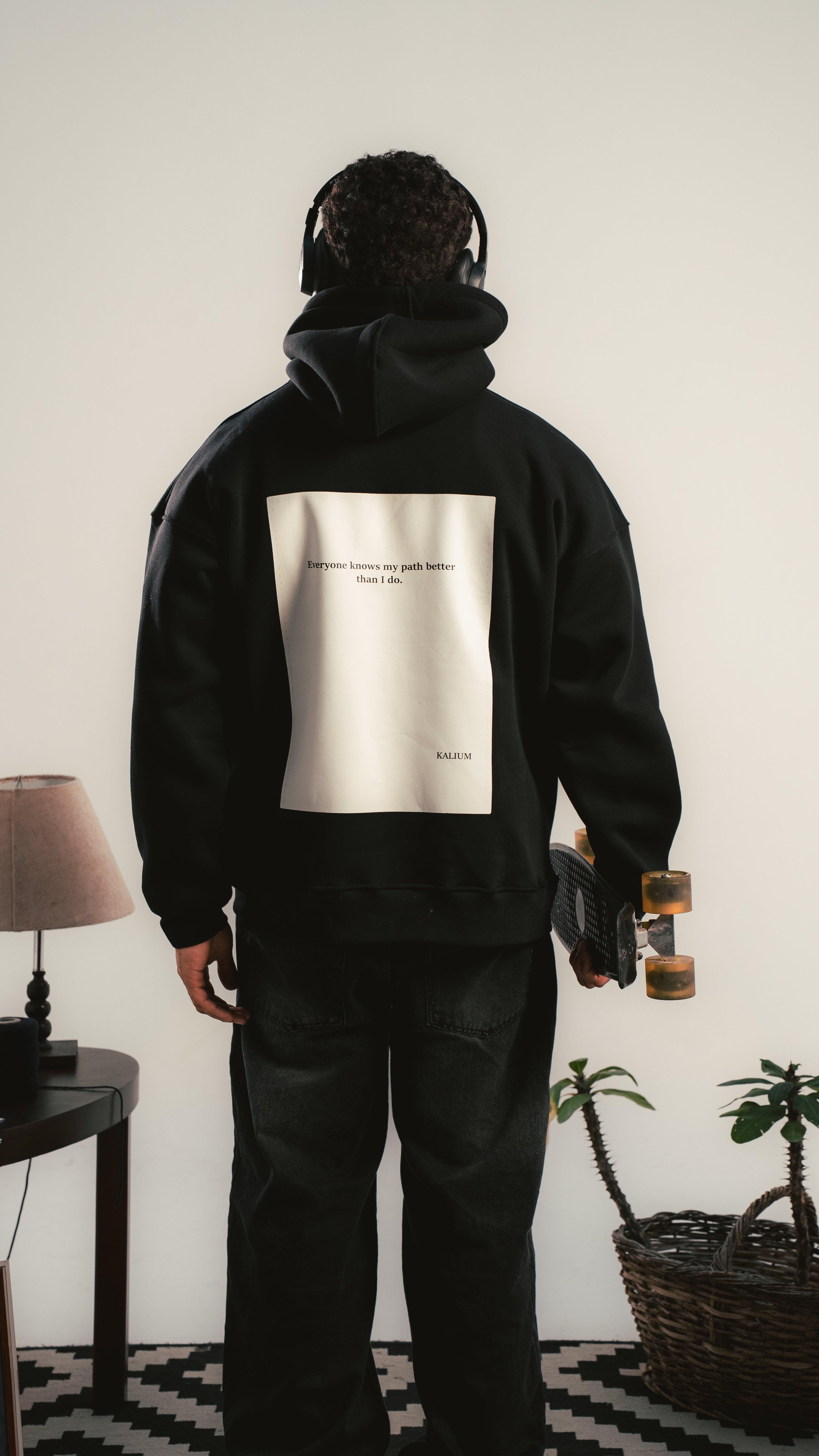 شاب يرتدي هودي أسود بطباعة كبيرة على الظهر — Kalium