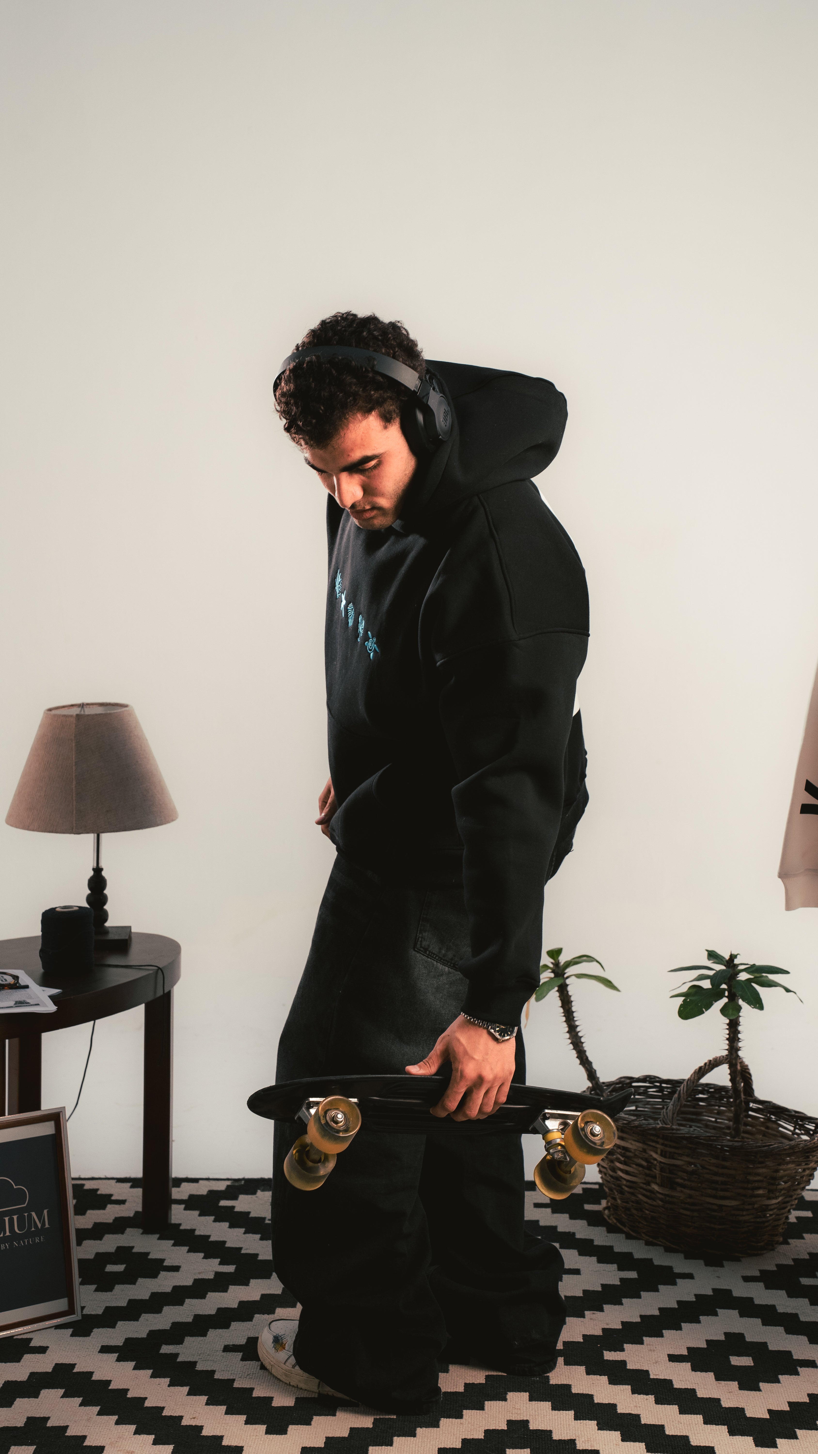 Black hoodie streetwear look — model holding skateboard — Kalium