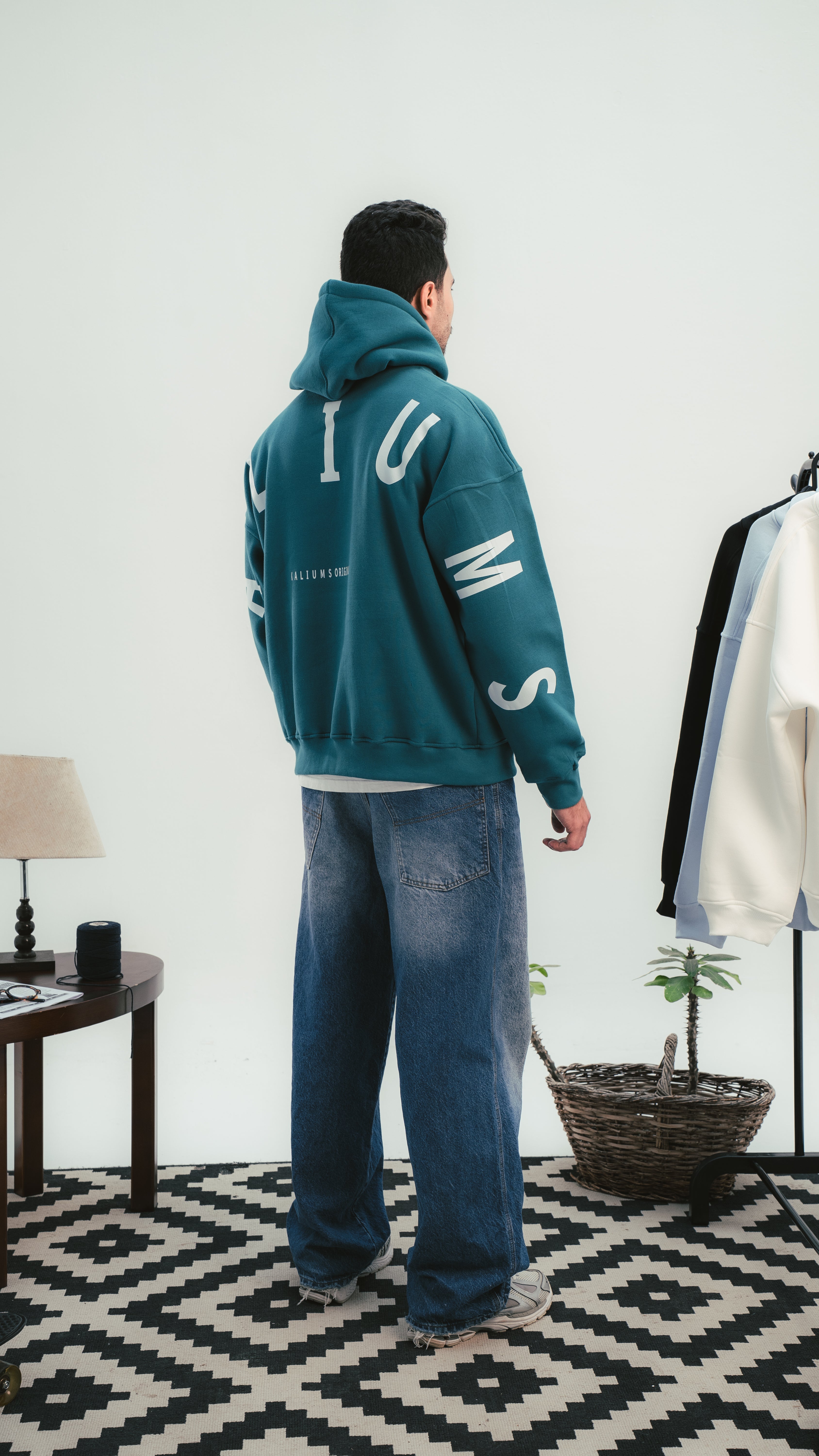 شاب يرتدي هودي Kalium الأخضر – لقطة جانبية تُظهر تفاصيل التصميم