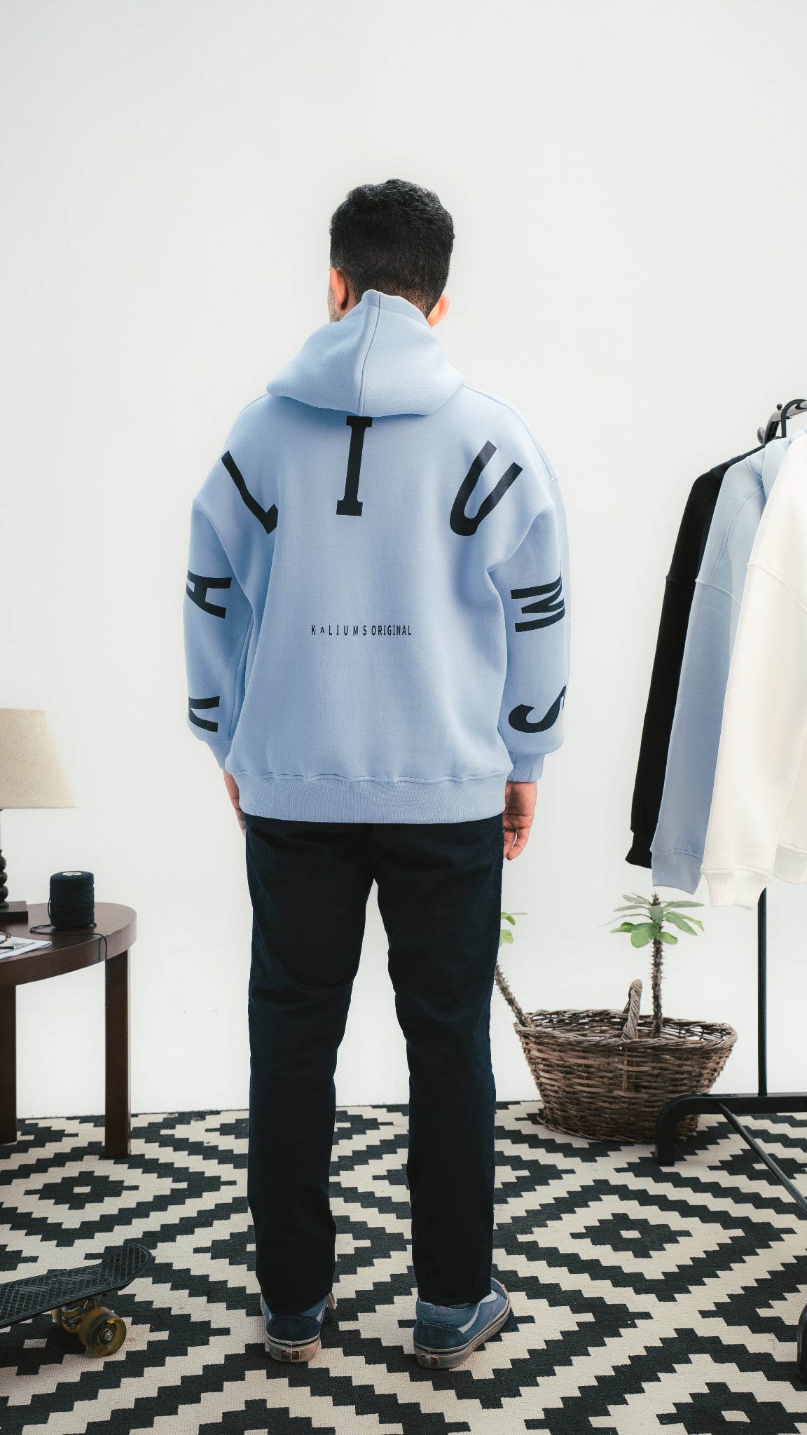 شاب يرتدي هودي Baby Blue من Kalium بتصميم خلفي كبير — لقطة من الخلف