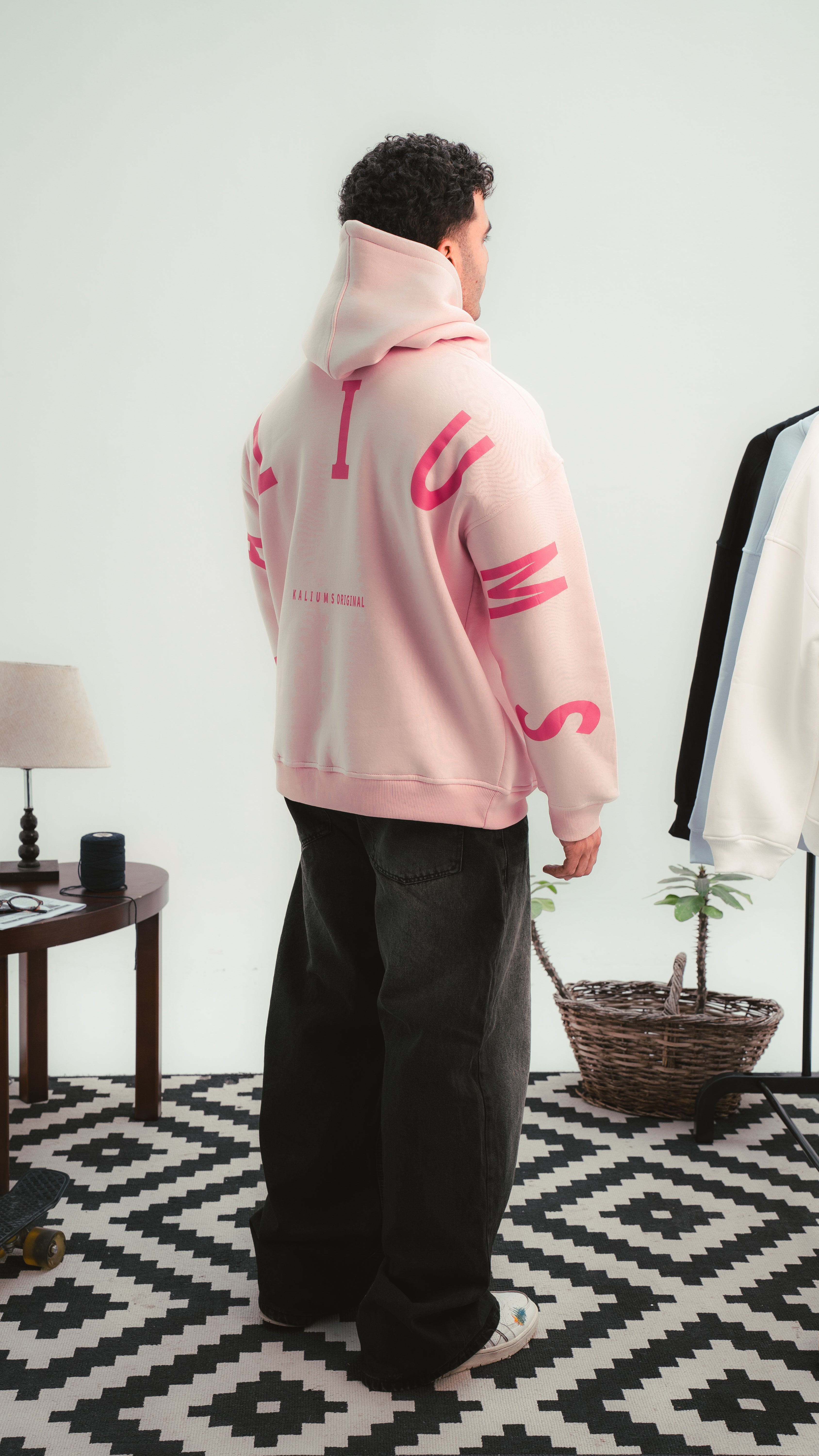 هودي وردي من Kalium بتصميم خلفي واضح وحروف كبيرة على الذراعين — لقطة جانبية